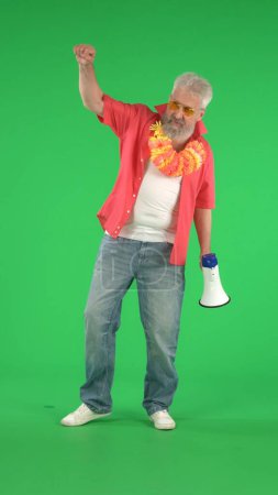 Photo for Creative modern seniors concept. Portrait of senior hipster on Chroma key green screen background, man shows strong gesture holding megaphone. Advertising area, workspace mockup. Vertical photo. - Royalty Free Image