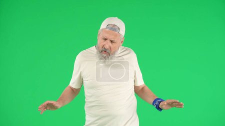 Photo for Creative modern seniors concept. Portrait of senior man hipster on Chroma key green screen background, man in white t-shirt dancing at the camera looking cool. Advertising area, workspace mockup. - Royalty Free Image