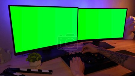 Photo for Video and photo editing creative concept. Freelancer working on agency from home. Closeup portrait of man working at the desk looking in chroma key monitors editing video settings using mixer. - Royalty Free Image