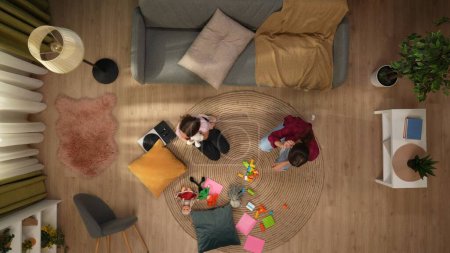 Foto de En el marco superior, una mujer y un niño, la familia se sientan en el suelo de la habitación, junto al sofá. Alrededor hay juguetes, juegan, se divierten. Retrata el ocio familiar, entretenimiento, amor. Vista superior. - Imagen libre de derechos