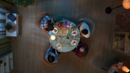 Photo for Family bonding and relationships concept. Scene in the apartment room. Top view of party table with food and drinks. Couple with friends celebrating husband birthday, cake with candles on the table. - Royalty Free Image