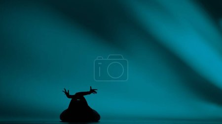 Photo for Woman silhouette dancing heels dance in a studio. Bright cyan, light, shadowed background. Black sexy costume, high heels. Modern sensual choreography. Full length. Promotional clip or advertisement. - Royalty Free Image