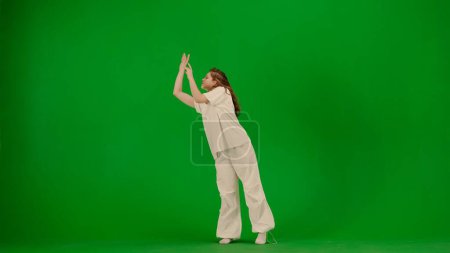 Téléchargez les photos : Chorégraphie créative moderne et concept de danse. Portrait de danseuse. Jolie jeune fille en tenue blanche dansant montrant la danse contemporaine émotionnelle sur fond d'écran vert clé chroma. - en image libre de droit