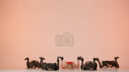 Photo for Framed against a pink background. Collective of young women in revealing clothing. Demonstrate a dance number, movement in the direction of high heels, stretching. They are beautiful, slender, plastic - Royalty Free Image