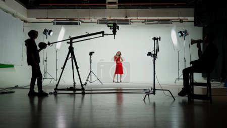 Photo for Music Clip Studio Set: Shooting Hip Hop Video Dance Scene with Three Professionals Dancers Performing on Stage with Big Led Screen with Modern City Background. Director and Cameraman in Backstage. - Royalty Free Image