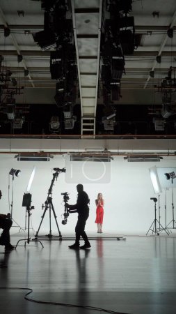 Téléchargez les photos : Clip musical Studio Set : Tournage Hip Hop Vidéo Scène de danse avec trois professionnels Danseurs performant sur scène avec grand écran LED avec fond de ville moderne. Réalisateur et cameraman en coulisses. - en image libre de droit