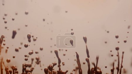 Photo for Splashes of dark chocolate on a light background. - Royalty Free Image