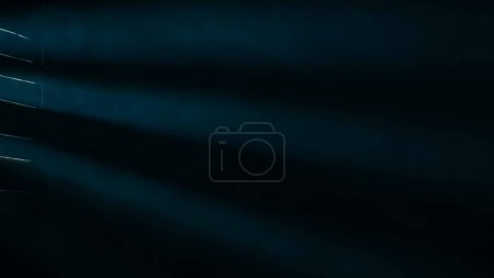 Foto de Un humo ondulante o niebla sobre un fondo negro, iluminado por un foco y una luz de neón azul que entra a través de las fajas de la ventana. Textura y arte abstracto - Imagen libre de derechos
