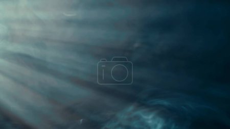 Foto de Flujo de humo azul en el centro de atención y luz de neón. Humo colorido sobre un fondo negro, adecuado para publicidad hookah, vape - Imagen libre de derechos