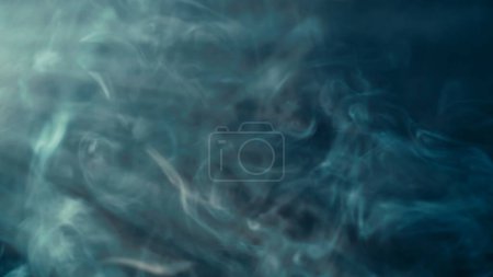 Foto de Flujo de humo azul en el centro de atención y luz de neón. Humo colorido sobre un fondo negro, adecuado para publicidad hookah, vape - Imagen libre de derechos