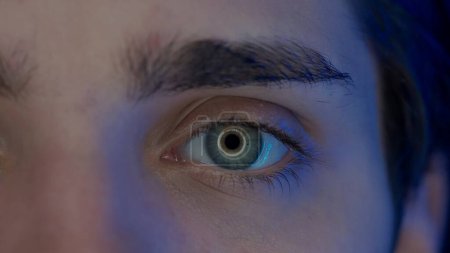 Foto de Ojo de un joven macro disparo. Luz azul desde un teléfono inteligente, la pantalla del ordenador se refleja en los ojos del hombre. Concepto de salud - Imagen libre de derechos
