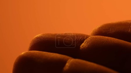 Téléchargez les photos : Dessin détaillé de la peau des doigts. Peau humaine de médecine de gros plan. Surface nue saine. Lumière orange. - en image libre de droit