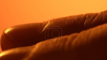 Foto de Dibujo detallado de la piel de los dedos. Piel humana de medicina de primer plano. Superficie desnuda saludable. Luz naranja. - Imagen libre de derechos