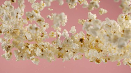 Téléchargez les photos : Popcorn tombant, isolé sur fond rose - en image libre de droit