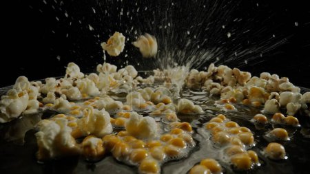 Photo for Popcorn popping on black background shooting with high speed camera. - Royalty Free Image