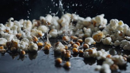 Photo for Popcorn popping on black background shooting with high speed camera. - Royalty Free Image