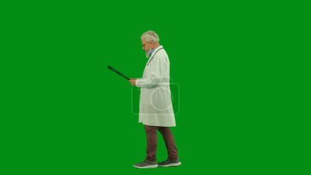 Téléchargez les photos : Santé et bien-être concept créatif. Portrait d'homme médecin en studio sur écran vert chromatique. Médecin principal en uniforme blanc marchant lisant une image radiographique tenant à la main. Vue latérale. - en image libre de droit