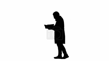 Photo for Healthcare and wellness creative concept. Portrait of man medic in studio isolated on white background alpha channel. Senior doctor silhouette in uniform walking and reading papers, side shot. - Royalty Free Image