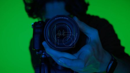 Photo for Professional male photographer working in studio. It uses colored neon lighting - Royalty Free Image