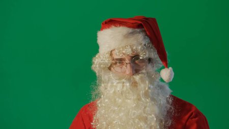 Foto de Retrato de un joven Papá Noel sobre un fondo verde. - Imagen libre de derechos