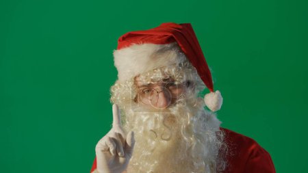 Foto de Retrato de un joven Papá Noel sobre un fondo verde. - Imagen libre de derechos