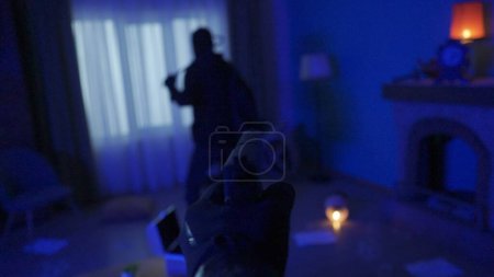Photo for First person shooter. The hand with the gun is pointed at the robber. Multiplayer game for computers and smartphones - Royalty Free Image