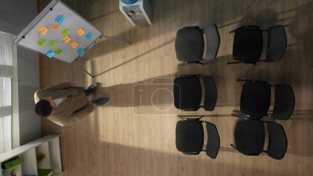 Photo for In the picture above there is a middle aged man in an empty room, an auditorium. He is waiting for the arrival of his group, students. At this time, thinking about something, preparing for a lecture. - Royalty Free Image