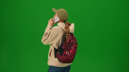 Photo for Airport creative advertisement concept. Portrait of person tourist isolated on chroma key green screen background. Close up shot young woman talking on smartphone looking at the departure board. - Royalty Free Image
