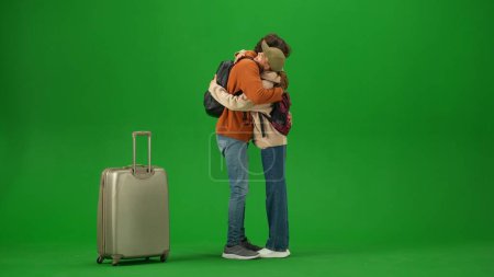 Photo for Airport creative advertisement concept. Portrait of person tourist isolated on chroma key green screen background. Young couple meets at the arrival area, man and girl hugging happy expression. - Royalty Free Image