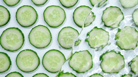 Photo for Slice of cucumber underwater or in water with splashing and droplet top view flat lay on white background - Royalty Free Image