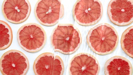 Photo for Slice of grapefruit underwater or in water with splashing and droplet top view flat lay on white background - Royalty Free Image