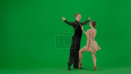 Foto de Un elegante dúo de baile de salón realiza una rutina dinámica capturada sobre un vívido fondo de pantalla verde. Esta imagen es perfecta para proyectos que requieren composición de croma key, ofreciendo un - Imagen libre de derechos