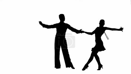 Foto de Esta llamativa imagen captura la silueta de una pareja de bailarines de salón en una pose dinámica, mostrando la elegancia y la pasión de la danza. El hombre y la mujer son representados en medio de la danza paso, sus cuerpos - Imagen libre de derechos