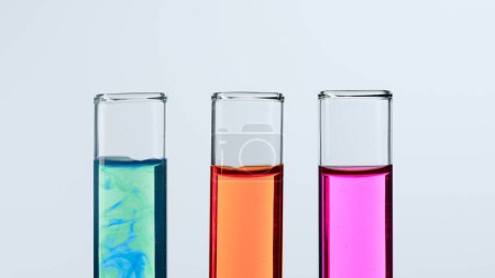 Photo for Concept of science and biotechnology. Laboratory glassware on white background. Test tubes filled with pink, green and red liquid. Close up - Royalty Free Image