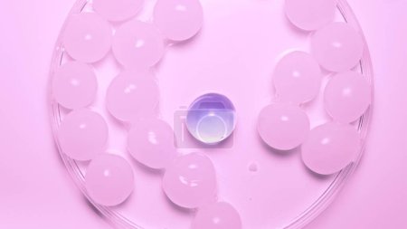 Foto de Muchas esferas de hidrogel blanco con una púrpura. Las brillantes esferas redondas de gel brillan sobre el fondo blanco del estudio - Imagen libre de derechos