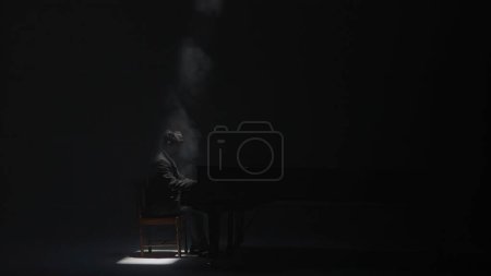 Téléchargez les photos : Musique et instruments concept publicitaire créatif. Gros plan du piano classique. Beau piano noir en fumée debout dans le studio sur fond blanc, projecteur sur chaise, musicien jouant. - en image libre de droit