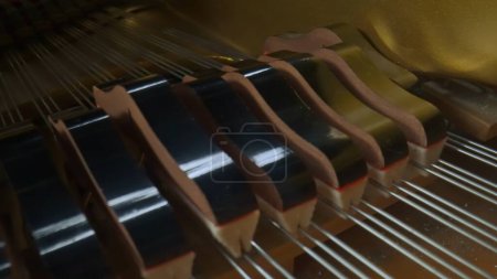 Photo for Music and instruments creative advertisement concept. Close up studio shot of classical piano. Shot inside the piano with wooden surface, hammers striking over the strings creating sound. - Royalty Free Image