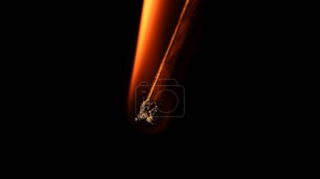 Foto de Macro toma de un partido en llamas contra un fondo oscuro del estudio. La llama de la cerilla encendida ilumina el espacio oscuro. El fósforo ardiente está envuelto en una llama naranja - Imagen libre de derechos