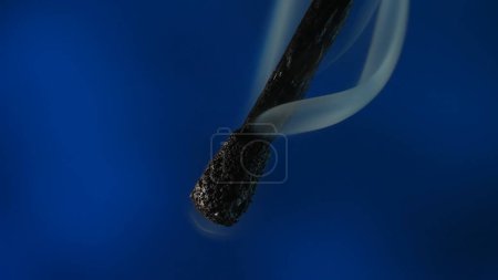 Photo for Macro shot of a black charred match and clouds of white smoke. Burned extinguished wooden match on dark studio background - Royalty Free Image