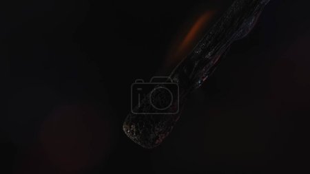 Téléchargez les photos : Match brûlant sur fond noir du studio. La flamme brûle la allumette en bois et elle s'estompe progressivement et s'assombrit. Concept de lumière et d'énergie. Macro shot - en image libre de droit