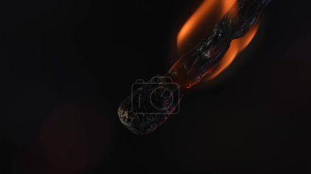 Photo for Burning match on black background of studio. The flame sizzles the wooden match and it gradually fades and dims. Concept of light and energy. Macro shot - Royalty Free Image