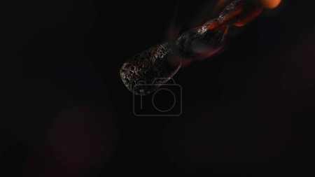 Foto de Coincidencia ardiente sobre fondo negro del estudio. La llama chisporrotea la cerilla de madera y se desvanece y atenúa gradualmente. Concepto de luz y energía. Macro tiro - Imagen libre de derechos