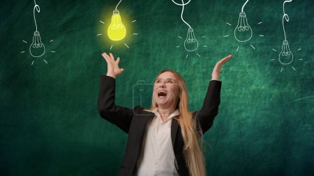 Photo for Portrait of a woman isolated on a green background, light bulbs are depicted on top. The girl is excited about the idea that has arisen. The light bulb glows as a symbol of a bright idea - Royalty Free Image