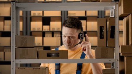 Photo for Business warehouse and logistics creative advertisement concept. Portrait of male working in storage. Man storekeeper standing near rack talking on smartphone about orders, smiling positive expression - Royalty Free Image