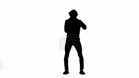 Photo for Silhouette of a male activist isolated on a white alpha channel. A Protestant man holds a megaphone near his mouth - Royalty Free Image