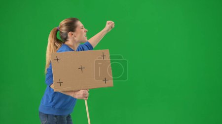 Photo for Female activist on green screen shouting protest slogans close up. Side view of a female protester. Advertising, promo, chroma key - Royalty Free Image