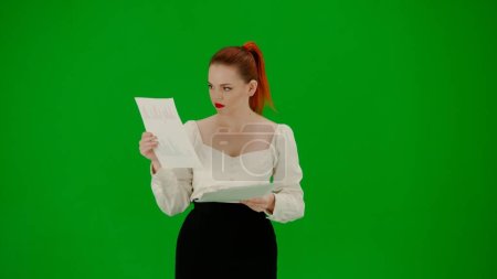 Foto de Mujer de negocios moderna concepto de publicidad creativa. Retrato de atractiva chica de oficina en croma pantalla verde clave. Mujer en falda y blusa leyendo documentos - Imagen libre de derechos