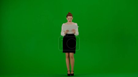 Photo for Modern business woman creative advertisement concept. Portrait of attractive office girl on chroma key green screen. Woman in skirt and blouse holding papers, frustrated throwing documents in the air. - Royalty Free Image