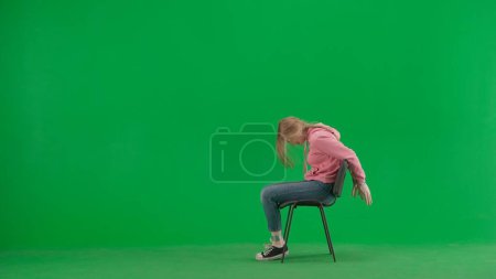 Photo for Robbery and criminal concept. Portrait of victim on chroma key green screen background. Girl sitting on the chair with tied hands, scared face expression, screaming for help. - Royalty Free Image