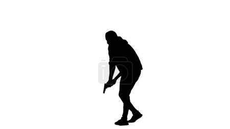 Téléchargez les photos : Silhouette noire de voleur sur fond blanc isolé. Un homme cambrioleur en sweat à capuche et cagoule marchant avec une arme dans les mains, se préparant à commettre un crime. Demi-tour - en image libre de droit
